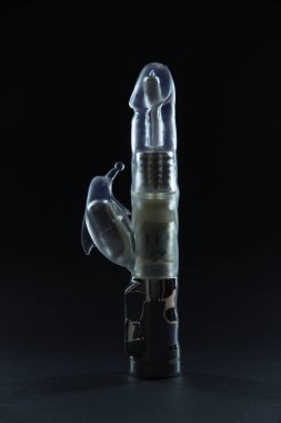 Sex toys on a black background. Large dildo vibrator with batter