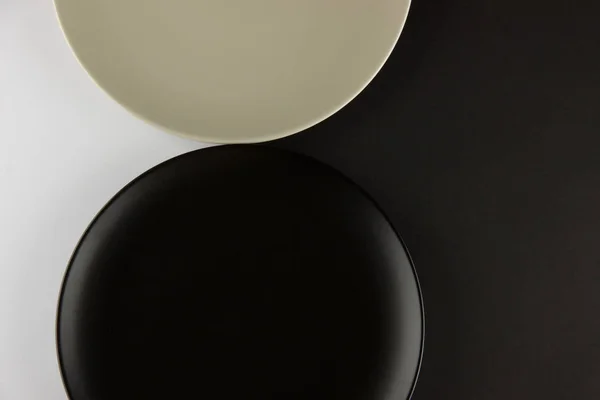 Eine Reihe flacher Teller und Tassen auf schwarzem und weißem Hintergrund — Stockfoto