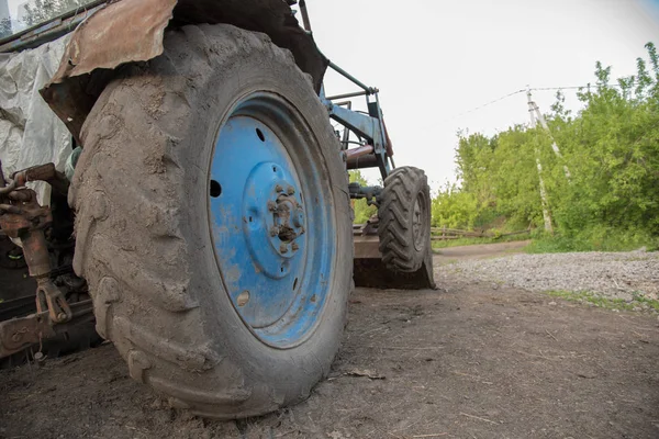 Detalles de un tractor de pueblo azul con ruedas sucias, motor, rud — Foto de Stock