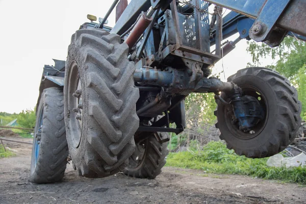 Detalles de un tractor de pueblo azul con ruedas sucias, motor, rud — Foto de Stock