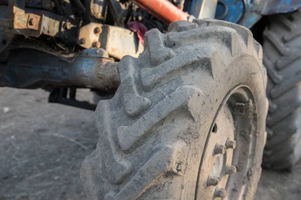 Detalles de un tractor de pueblo azul con ruedas sucias, motor, rud — Foto de Stock