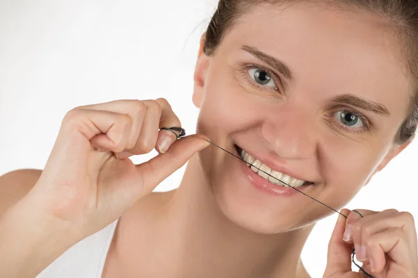 Hygiene of the oral cavity. Young girl cleans teeth with floss, — Stock Photo, Image