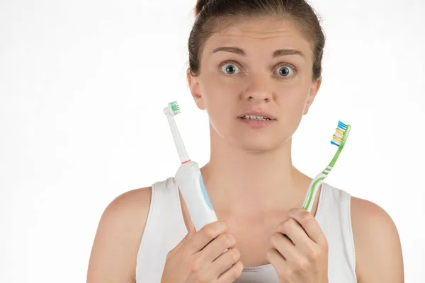 Higiene da cavidade oral. Uma jovem escolhe entre um elec — Fotografia de Stock