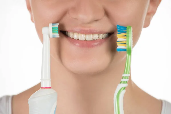 Higiene de la cavidad oral Una joven elige entre un elec —  Fotos de Stock