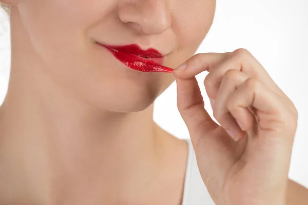 Ein schönes junges Mädchen trägt einen anhaltenden flüssigen roten Lippenstift auf — Stockfoto