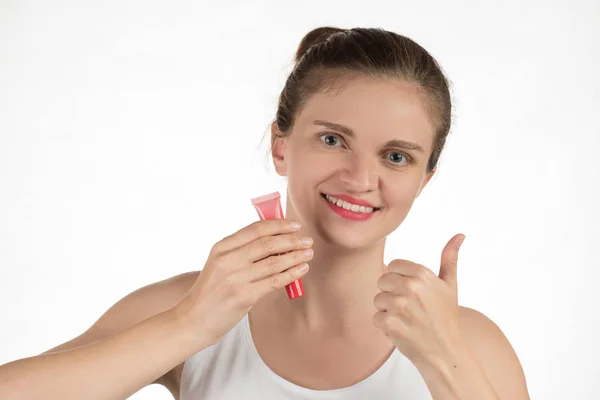 Una hermosa joven aplica un lápiz labial rojo líquido persistente —  Fotos de Stock