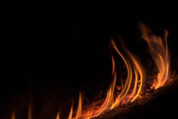 背景的橙色和红色火花从一堆篝火在晚上 — 图库照片