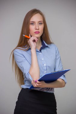 Genç güzel iş kadını bir belge tablet ve kalem tutan ve gri arka plan üzerinde düşünme