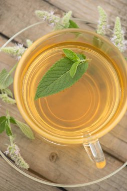 Altın çay yaprakları ve nane çiçek st ile ile ile bir cam kupa