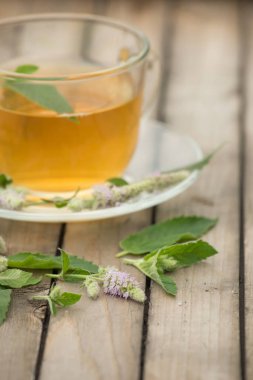 Altın çay yaprakları ve nane çiçek st ile ile ile bir cam kupa