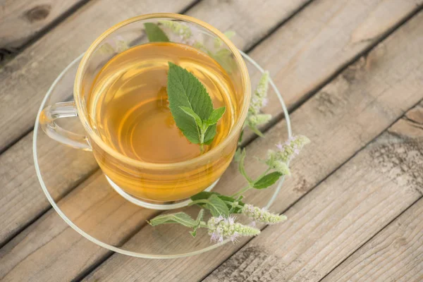 Altın çay yaprakları ve nane çiçek st ile ile ile bir cam kupa
