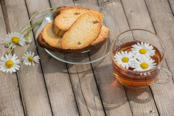 Bitkisel çay papatya ve ahşap bir t bir cam tabakta Peksimet