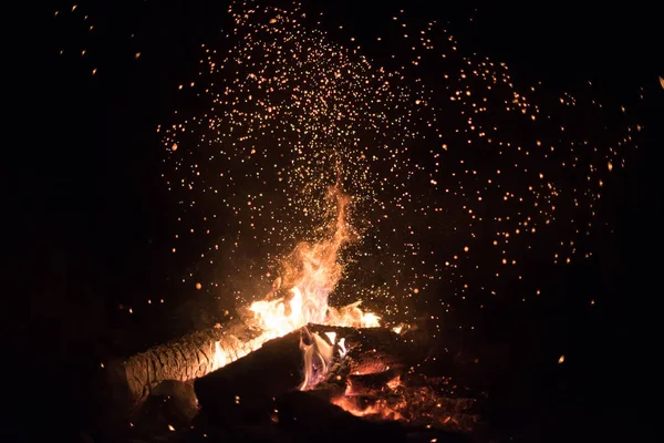 Turuncu ve kırmızı arka plan bir kamp ateşi geceleri kıvılcım.