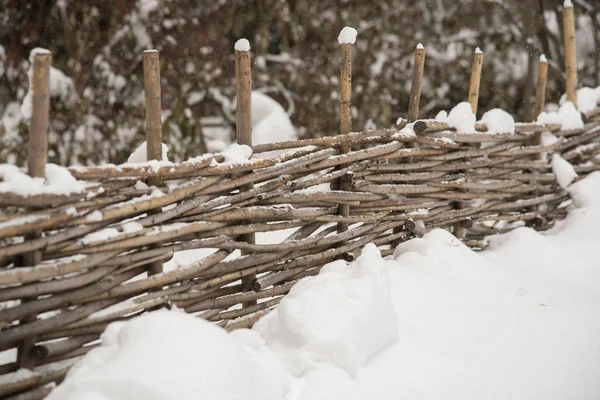 Recinzione in legno di rami d'albero ricoperti di neve — Foto Stock