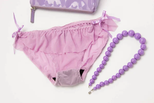 Lilac panties, necklace of beads and cosmetic bag on white backg — Stock Photo, Image