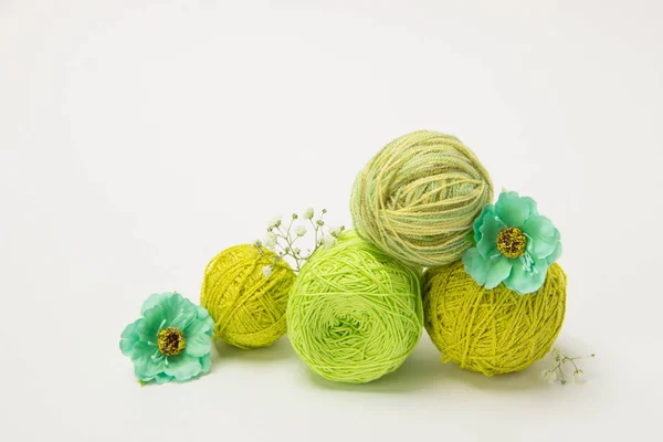 Πράσινο νήμα για πλέξιμο στο μπέρδεμα και τις βελόνες με λουλούδια στο — Φωτογραφία Αρχείου