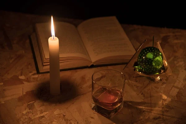 Чарівний м'яч, сувій, свічка, келих коньяку та старі книги в темряві ночі — стокове фото