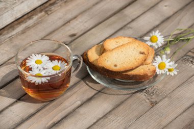 Bitkisel çay papatya ve ahşap bir t bir cam tabakta Peksimet