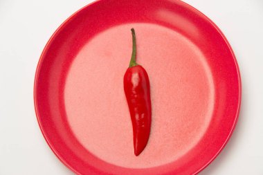 Bir plaka üzerinde beyaz bir arka plan üzerinde kırmızı acı biber