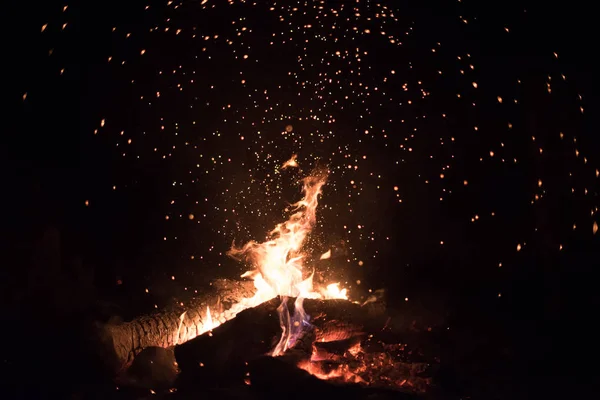Turuncu ve kırmızı arka plan bir kamp ateşi geceleri kıvılcım.