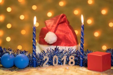 Mavi gelin teli, bir top, mum, bir kap ve bir hediye ile 2018 arka planda bir yılbaşı Garland altın ışıklı bir masaya rakamlar