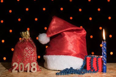 Yeni yıl kırmızı şapka, bir hediye, bir mavi mum ve boncuk zekâ ile bir çanta
