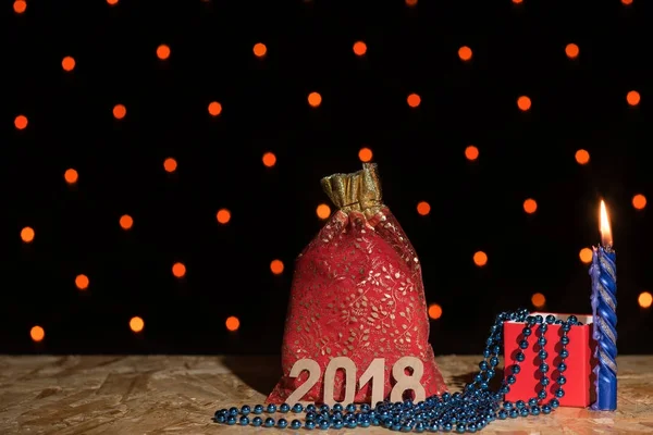 Новорічна червона сумка з подарунком, синя свічка і бісер з онімінням — стокове фото