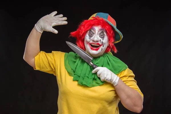 Enge clown met een afschuwelijk make-up lacht en met messen in ha — Stockfoto
