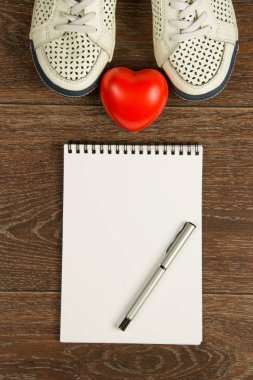 Kadın ayakkabıları, kalp, kalem ve beyaz dizüstü düz