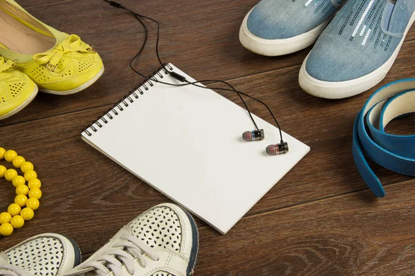 Women 's shoes, yellow beads, blue belt, black headphones and whi — стоковое фото