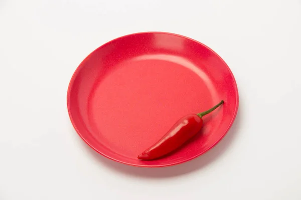 Rote Paprika auf einem Teller auf weißem Hintergrund — Stockfoto