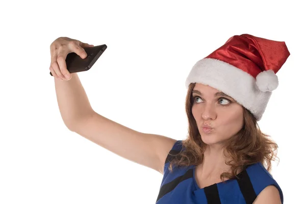 Menina em um chapéu de Ano Novo vermelho com um telefone celular em um fundo — Fotografia de Stock