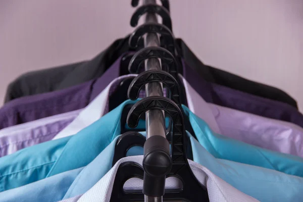 Camisas masculinas coloridas que penduram em cabides — Fotografia de Stock