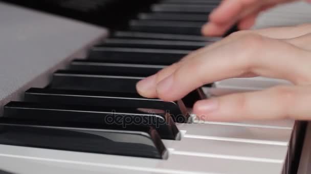 Beautiful fingers on white and black piano keys or a synthesizer play a melody — Stock Video