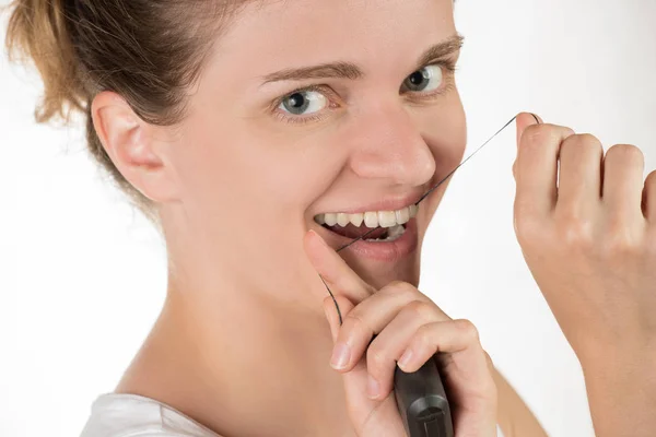 Hygiene of the oral cavity. Young girl cleans teeth with floss, — Stock Photo, Image