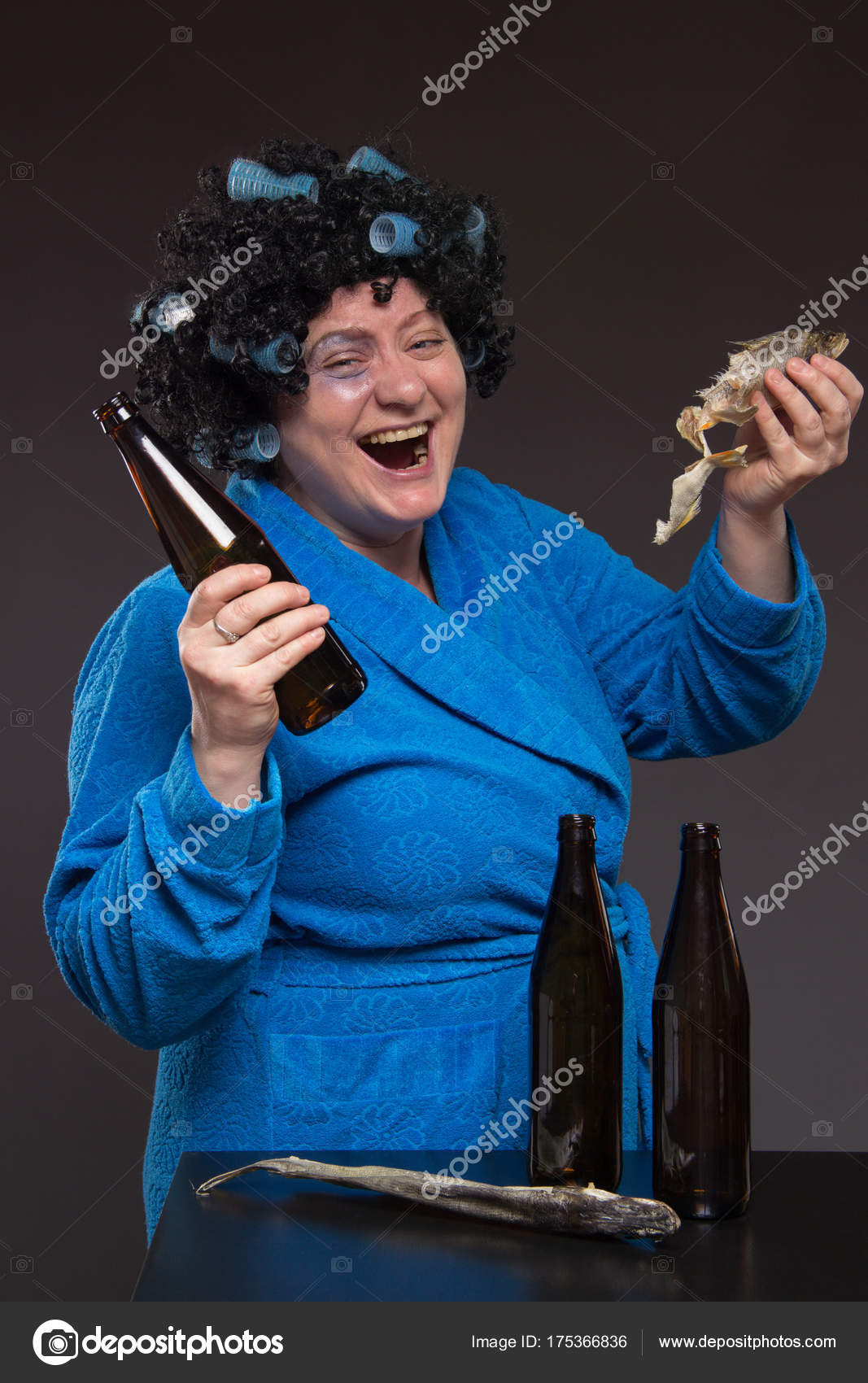 Lonely middleaged woman drinking beer and vodka and eating pick Stock