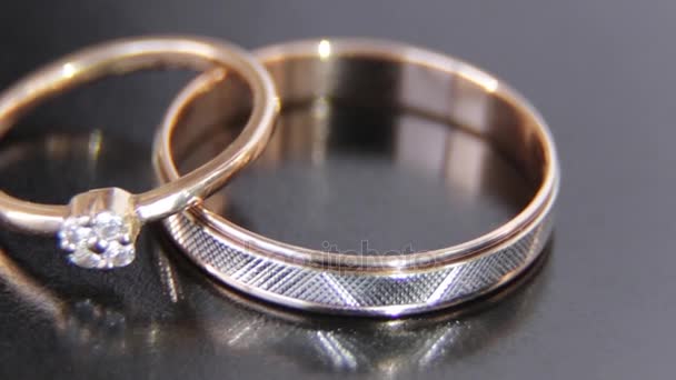 ホワイトゴールドとイエローゴールド宝石黒い背景に玉と つの美しい婚約指輪が刻まれました — ストック動画