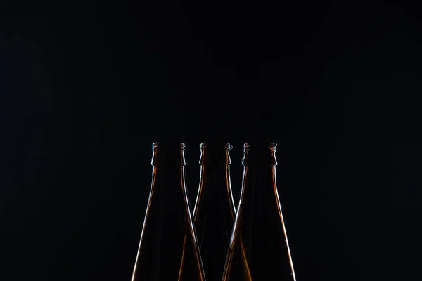 Silhouetten Glasflaschen für Bier auf schwarzem Hintergrund — Stockfoto