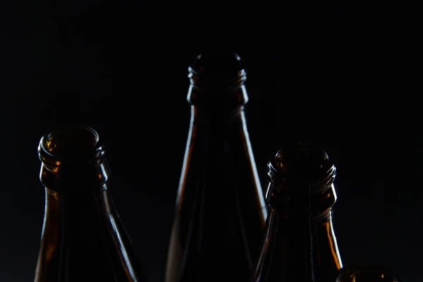 Garrafas de vidro de silhuetas de cerveja em um fundo preto — Fotografia de Stock
