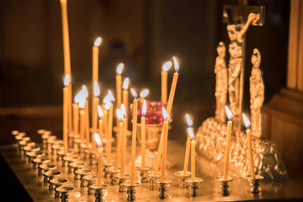 Hořící svíčky v kostele na pozadí ikon — Stock fotografie