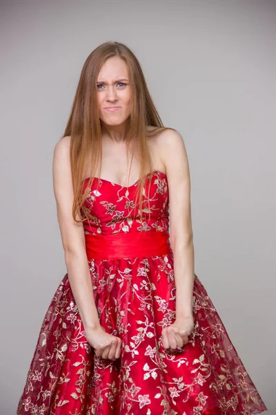 Mooie jonge blonde model in een jurk met een beledigd gezicht op — Stockfoto