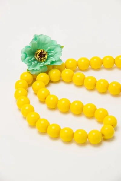 Collier de perles jaunes avec des fleurs vertes sur un fond blanc — Photo