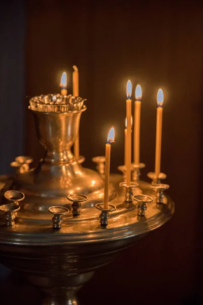 Brinnande ljus i kyrkan mot bakgrund av ikoner — Stockfoto