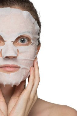 Güzel genç kadın bir yüz kozmetik maske üzerinde uygulama bir