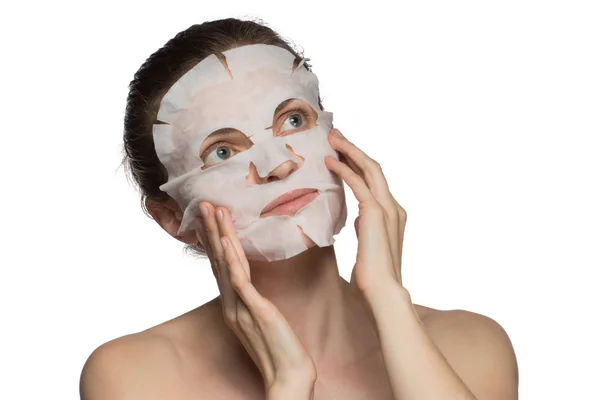 Hermosa joven está aplicando una máscara cosmética en una cara en un —  Fotos de Stock