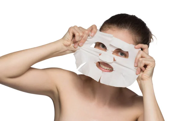 Hermosa joven está aplicando una máscara cosmética y sonriendo — Foto de Stock