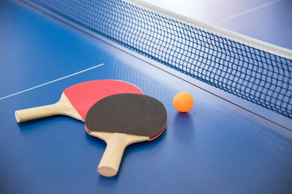 Orange ball for table tennis and two rackets of red and black co