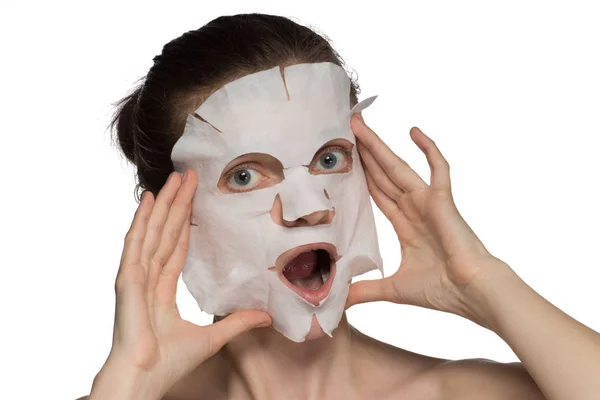 Krásná mladá žena je použití kosmetické masky a usmíval se na — Stock fotografie