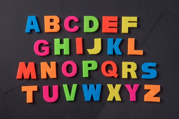 Angol ábécé betűit különböző színű, egy fekete főleg CIG — Stock Fotó