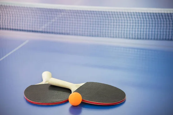 Orange ball for table tennis and two rackets of red and black co